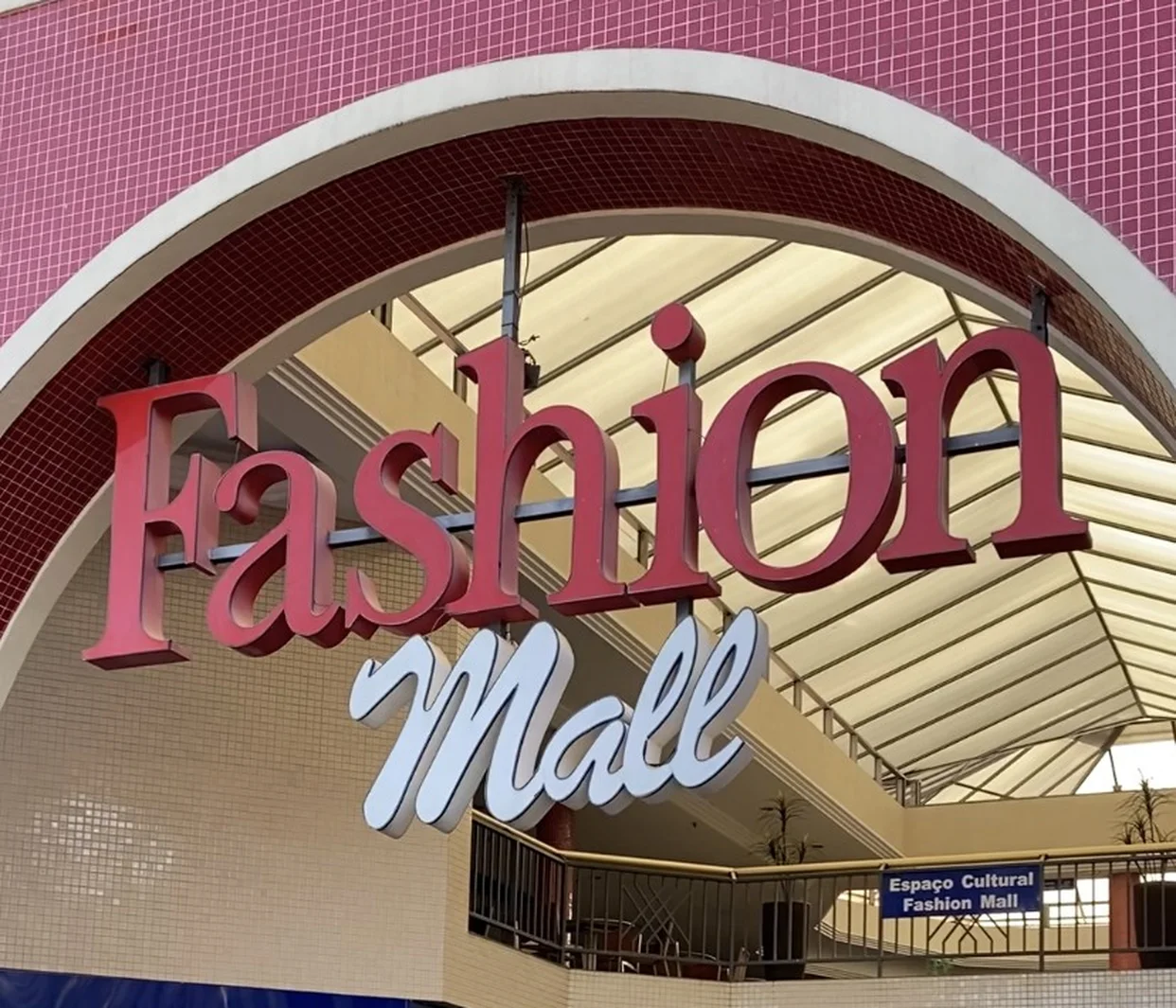 Entrada do Fashion Mall, com o letreiro vermelho e branco sob um arco, na entrequadra 302/303 Sul