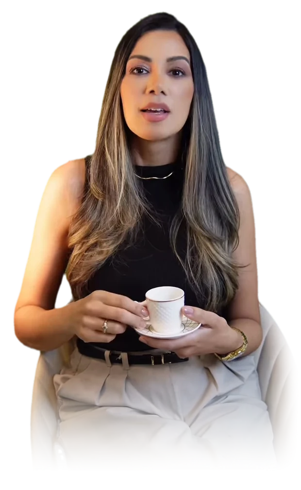 Dra. Daniela Nóbrega sentada, de regata preta, com uma xícara de café nas mãos, falando para a câmera